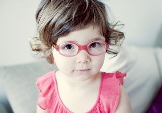 Une petite fille qui porte des lunettes roses