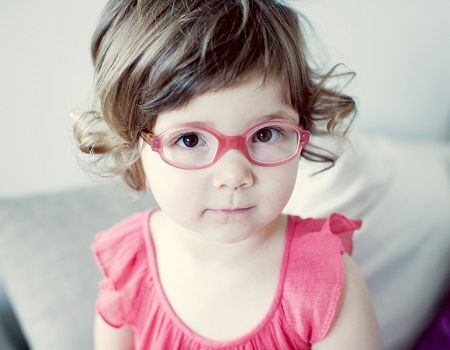 Une petite fille qui porte des lunettes roses